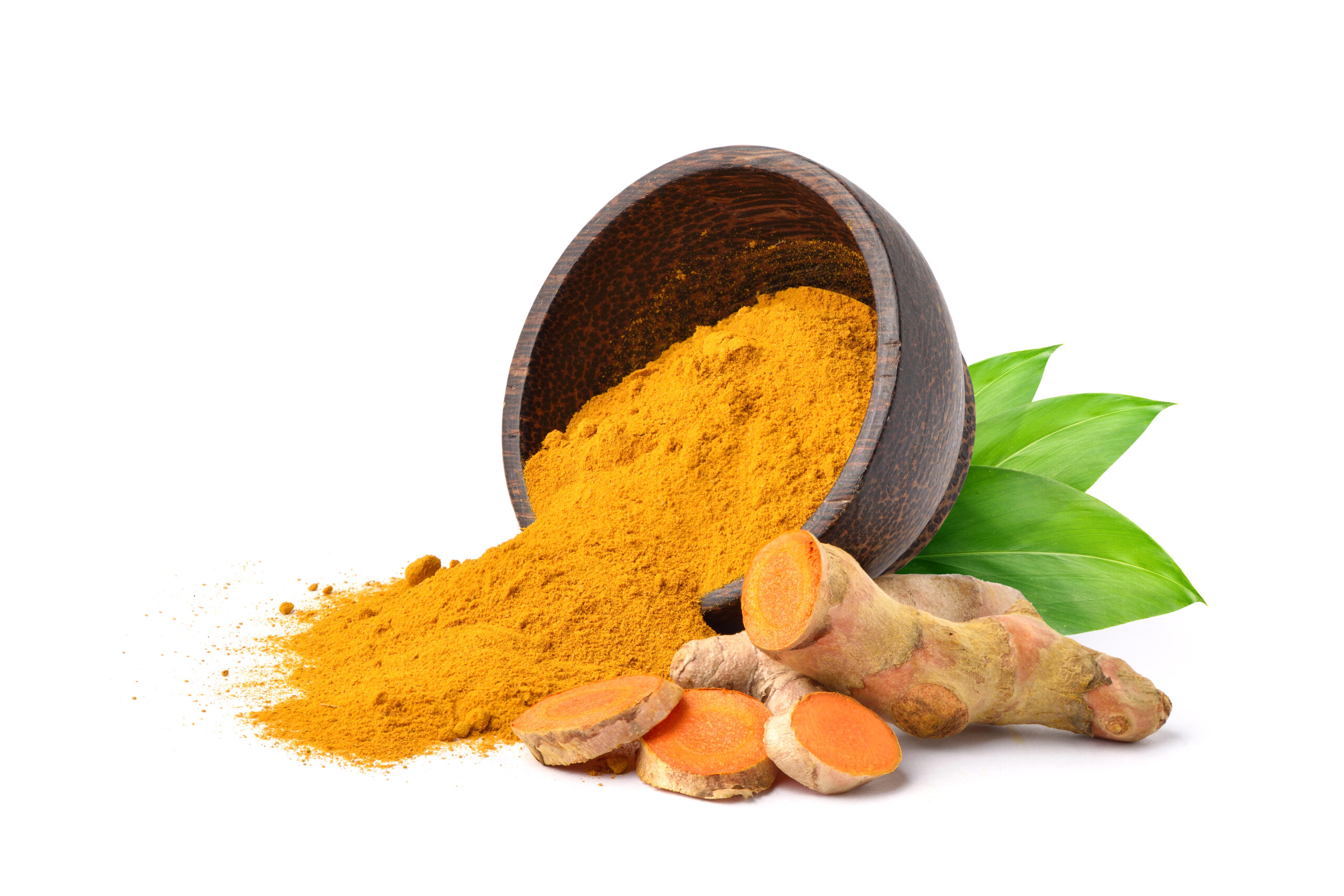 Turmeric (Curcuma longa Linn) powder pouring from the wooden bowl with rhizome (root) slices on white background.